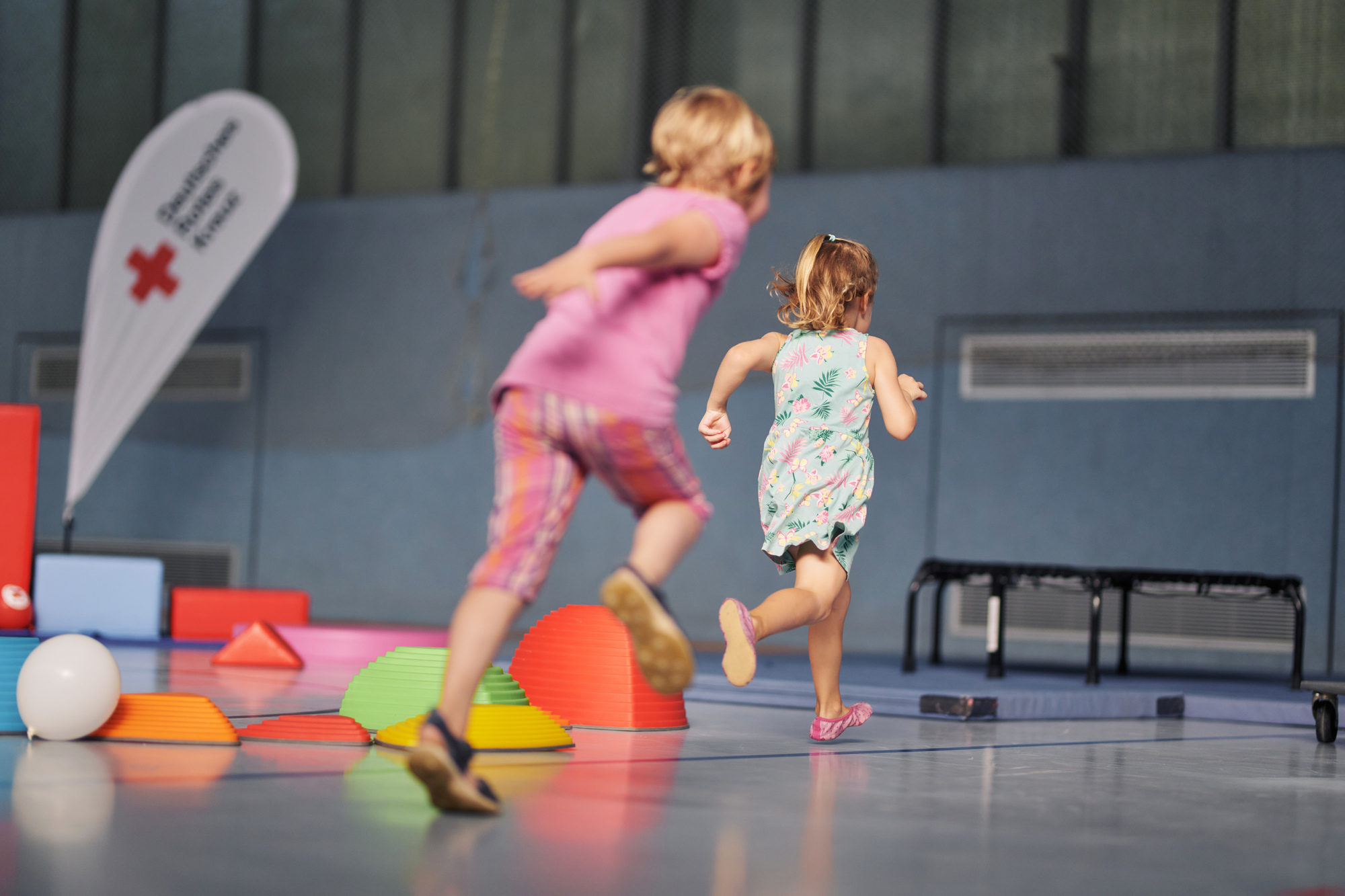Kinder beim Sport, Mädchen rennen in einer Turnhalle