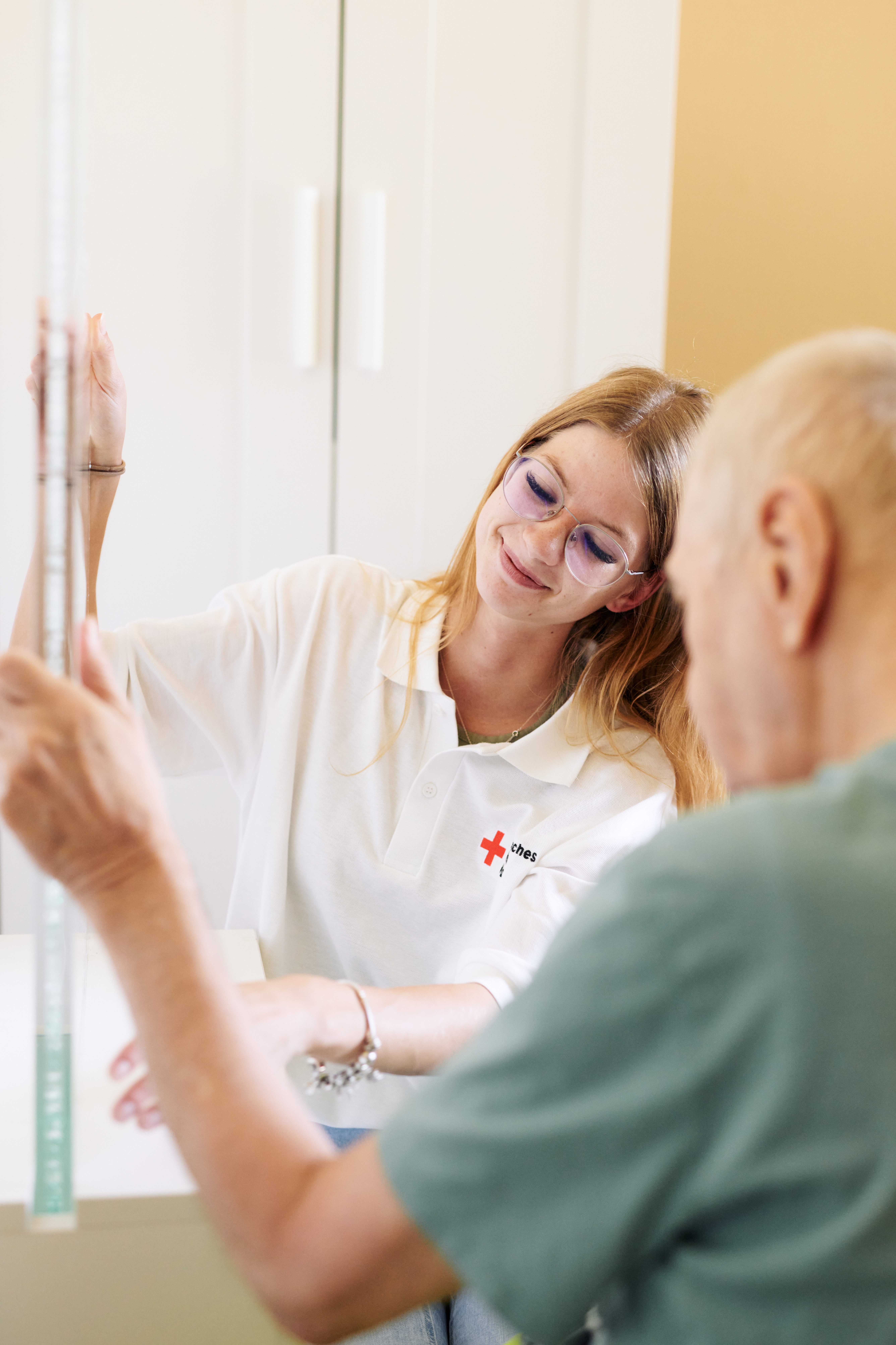 Eine Betreuerin im Therapieraum mit einem Bewohner 