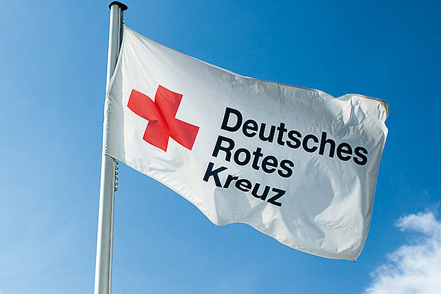 Symbolbild: Eine wehende Fahne mit der Aufschrift Deutsches Rotes Kreuz