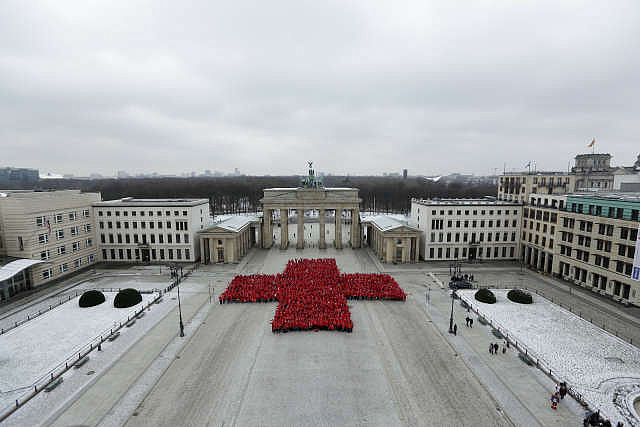 1800 ehrenamtliche DRK-Helfer bilden ein rotes Kreuz vor dem Brandenburger Tor, Ansicht von oben