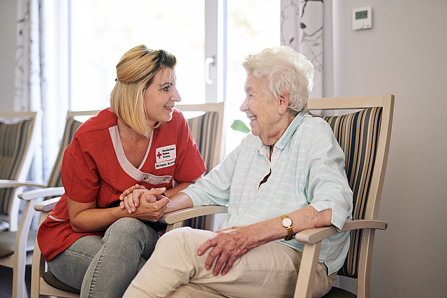 DRK Mitarbeiterin beim persönlichen Gespräch mit einer Seniorin