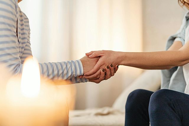 Zwei Personen halten sich die Hände
