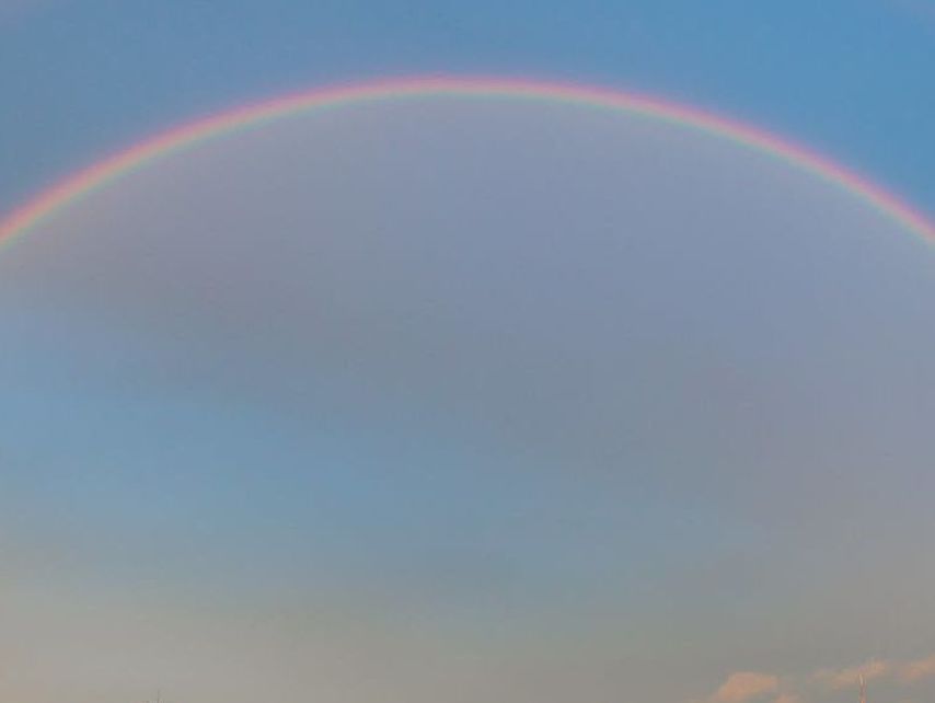 Regenbogen im Himmel über einer Stadt