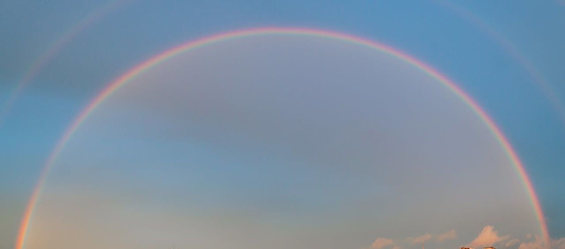 Regenbogen im Himmel über einer Stadt